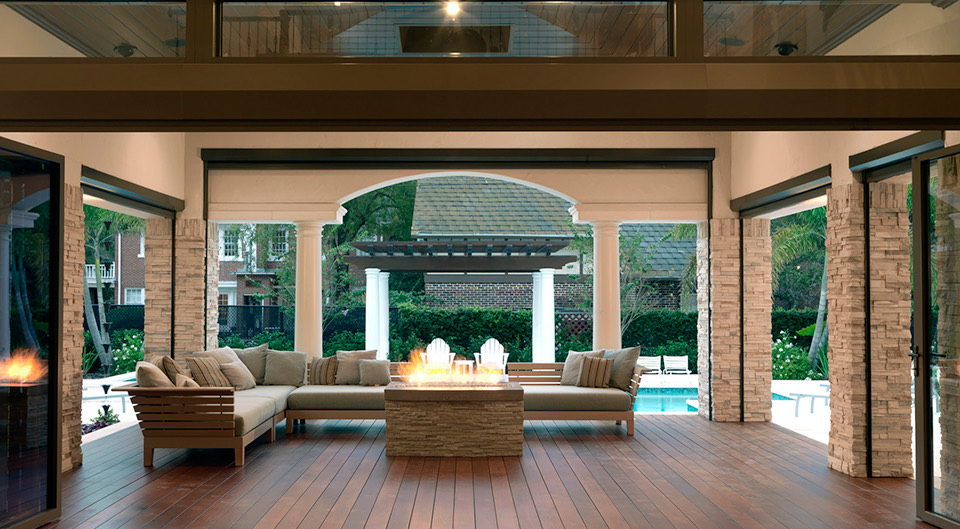 An open lanai with a fire feature and the pool beyond